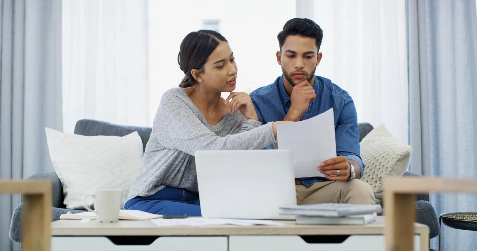 Couple reviewing loan paperwork together on a laptop at home
